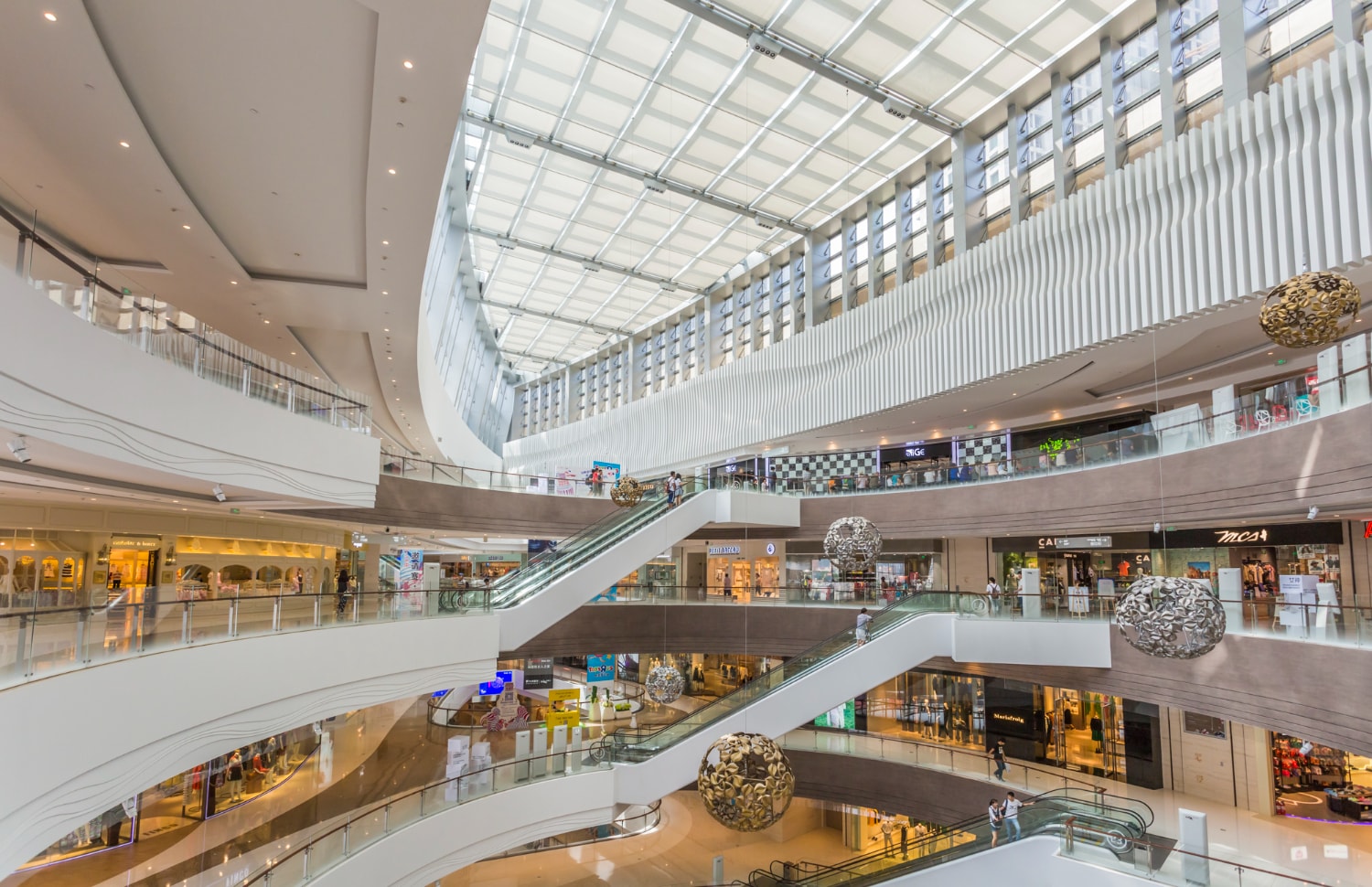 Galerien, Rolltreppen und Ladenfronten in einem mehrgeschossigen Einkaufszentrum
